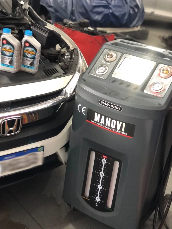 Máquina de diálise Mahovi para câmbio automático ao lado de frascos de óleo CVT Havoline