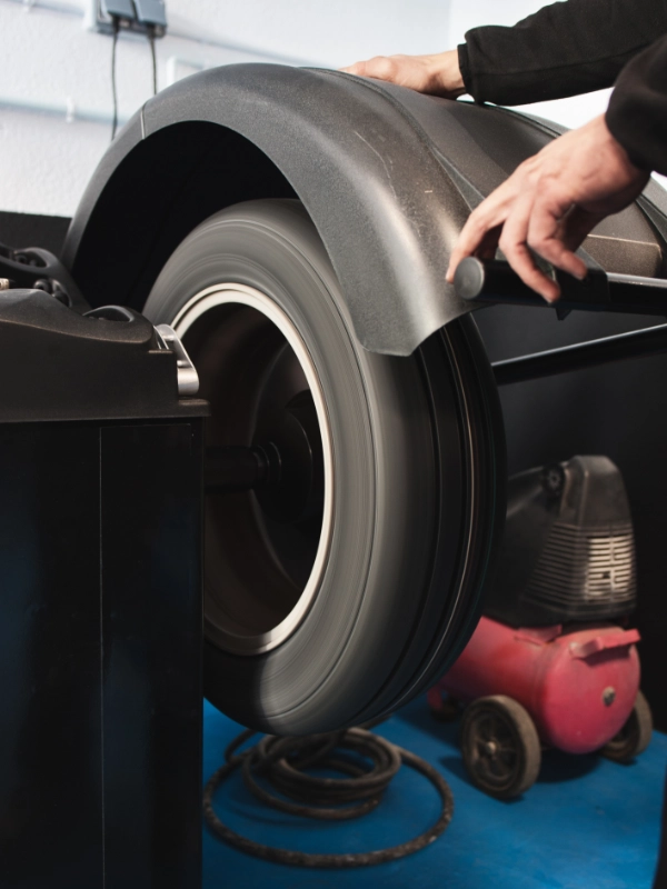 Pneu girando em máquina de balanceamento computadorizado durante ajuste técnico